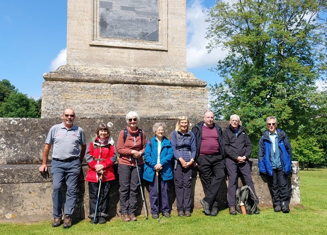 walkers standing in a line at the base of the memorial